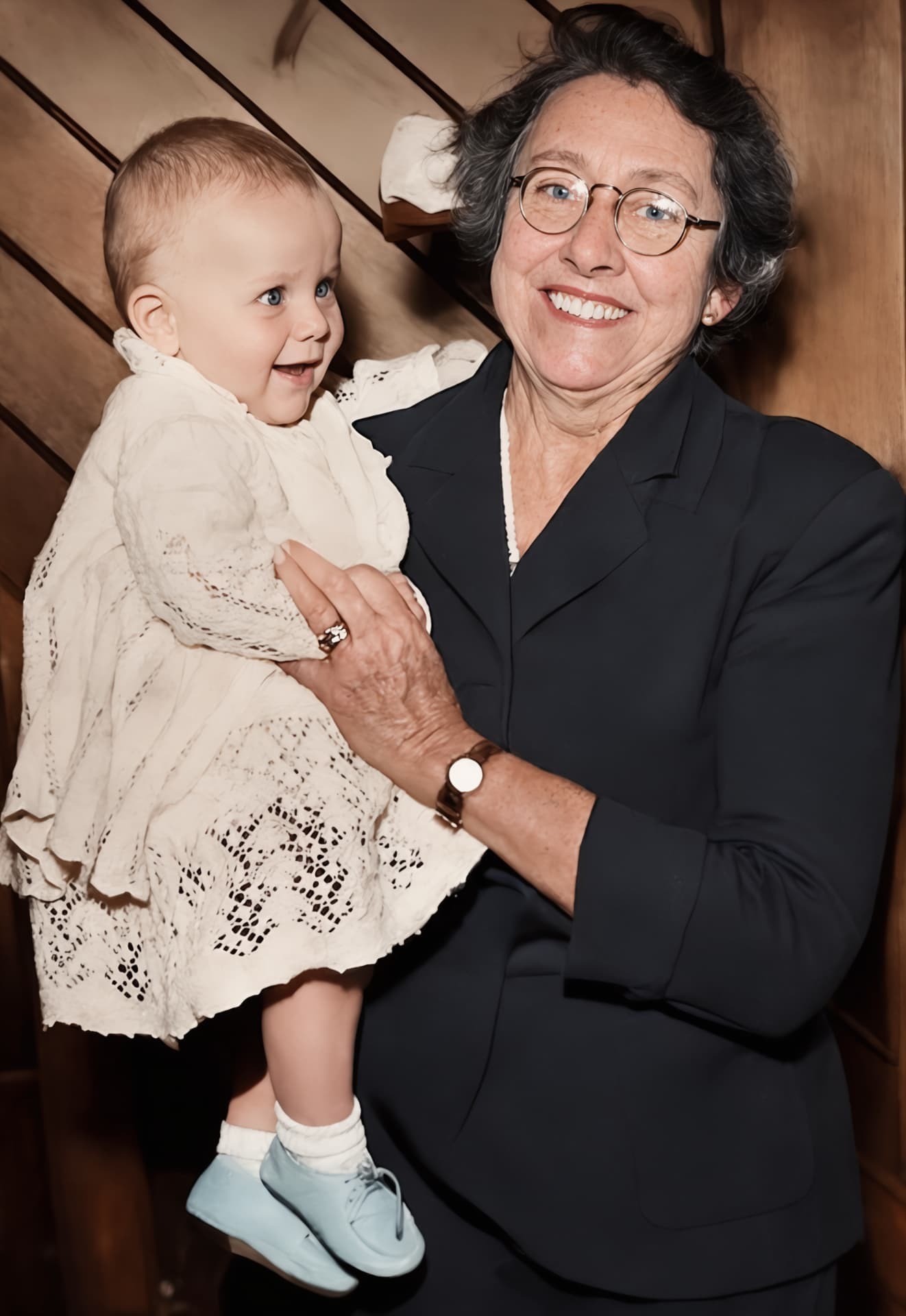 Restored photo after FixPix — Grandma and the baby — creases and stains repaired, gently colourised.
